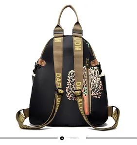Detail view of the wide shoulder straps with yellow lettering on a black travel backpack