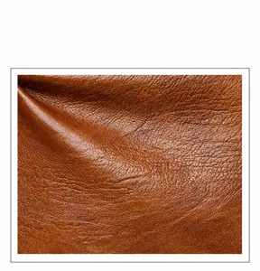 Nahaufnahme von braunem Leder mit Lychee-Muster zeigt weiche Textur und Haltbarkeit