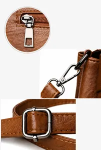 Detailaufnahme der glatten Reißverschlüsse und Metallbeschläge der braunen Ledertasche
