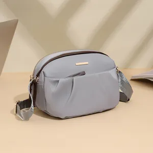 Waterproof grey nylon crossbody bag for women with adjustable strap and metal logo plate