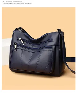 Detail of navy blue pebble leather tote with dual front zipper pockets and shoulder strap
