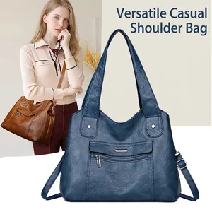 Detail of soft leather multi-pocket tote bags showing blue and brown options with straps