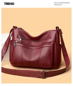 Detail of deep red tote bag with multiple zipper pockets and adjustable shoulder strap