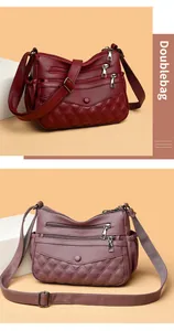 Détail du sac à bandoulière en cuir souple avec poches zippées et motif matelassé