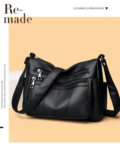 Detail of black pebbled leather tote bag featuring multiple silver zipper pockets and strap