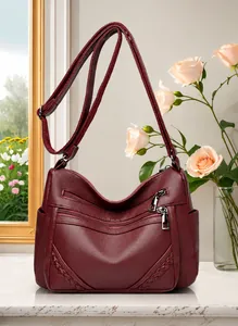 Detail van de wijnrode kunstleren crossbodytas met vlechtpatroon en ritsen