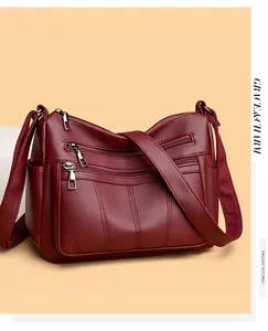 Close-up of wine red multi-zipper tote bag with textured litchi pattern leather finish