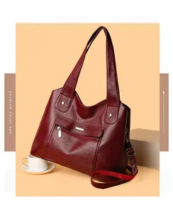 Close-up of wine red grainy leather tote bag with silver zipper detail and fashion print