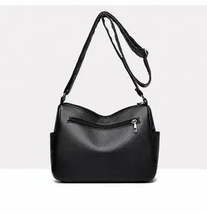 Detail view of the black tote bag back side featuring a zipper pocket and pebbled leather