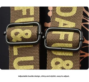 Detail of durable canvas strap with letter print and glossy metal adjustment buckles