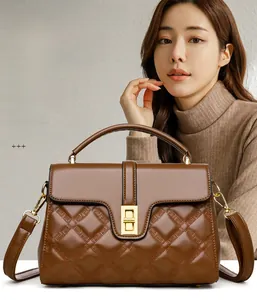 Détail du sac à main en cuir marron avec matelassage en losange et fermoir tournant doré