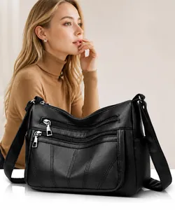 Detail of black pebbled leather tote bag with functional silver zippers and wide strap