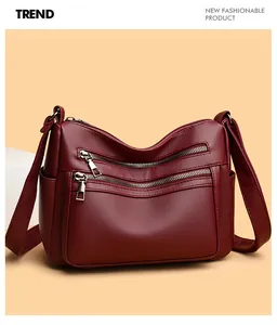 Détail du sac bandoulière bordeaux avec cuir texturé et doubles fermetures éclair avant