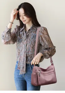 Close-up of pink tote bag with multi-zipper layers and pebbled faux leather texture