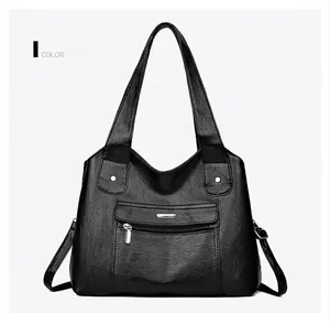 Close-up of black lychee texture leather bag with metal logo and front zipper details