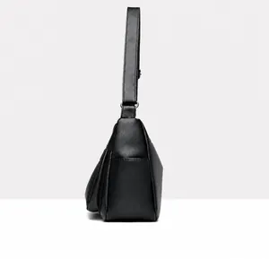 Side view of black faux leather tote bag showing wide shoulder strap and lychee texture