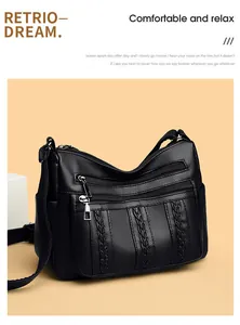 Detalle del bolso bandolera negro con textura litchi y cremalleras plateadas