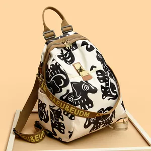 Cream canvas travel backpack featuring black elephant prints and durable nylon straps