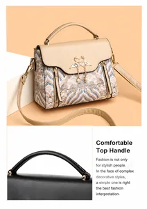 Detail van de gouden zwaan sluiting met parel op een geborduurde crossbody tas