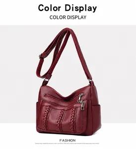 Detalle del bolso bandolera burdeos de piel suave con textura de grano y rayas tejidas