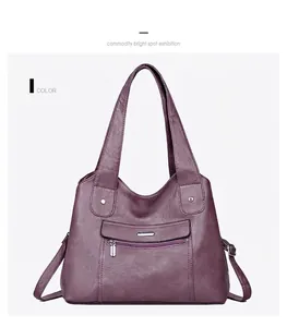Detail view of the soft leather texture and zipper pocket of the mauve tote bag
