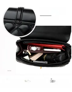 Détail de l'intérieur du sac matelassé noir avec compartiments multiples et grande capacité