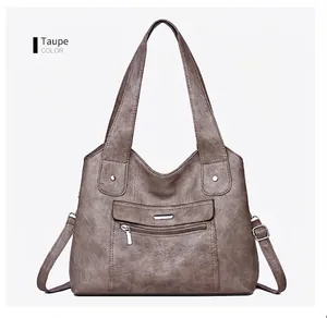 Detailed view of camel leather tote featuring multiple pockets and silver hardware