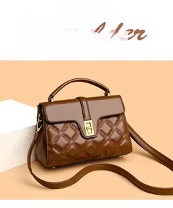 Détail du sac à main en cuir marron foncé avec fermoir doré et texture matelassée