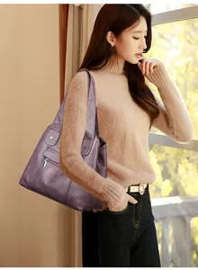 Detail of soft purple leather shoulder bag with zipper and metallic studs on the handle