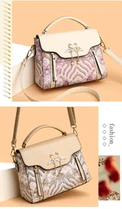 Détail de sacs à main à motifs géométriques avec fermoir cygne et pompon en perles