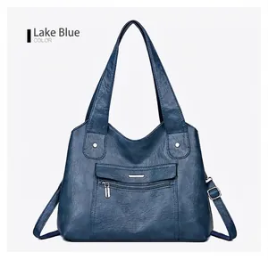 Detail view of lake blue soft leather tote bag featuring multiple front zipper pockets