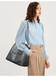 Detail view of large dark grey faux leather tote bag with adjustable shoulder strap