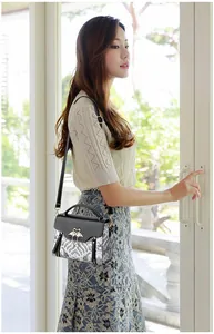 Femme portant l'élégant sac brodé avec une boucle dorée en forme de cygne chic