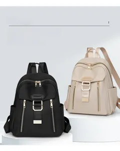 Front view showing black and beige waterproof nylon backpacks with metal zipper detail