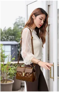 Détails du sac bandoulière marron foncé avec surpiqûres losanges et boucle dorée