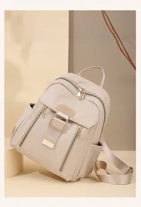 Detail of beige nylon travel backpack with premium gold metal buckles and multi-compartments