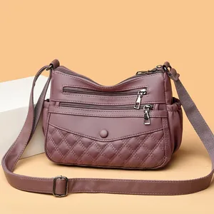 Sac à bandoulière mauve avec plusieurs fermetures éclair et motif matelassé