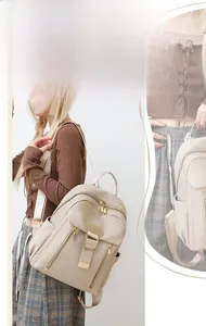 Detail of waterproof nylon backpack featuring metal buckles and branded leather patch