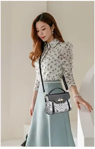 Détail d'un sac à main noir élégant avec broderie et fermoir cygne doré chic