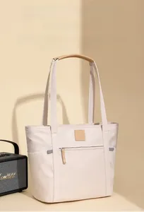 Detail of water-resistant crinkled fabric and multiple storage pockets on beige tote bag