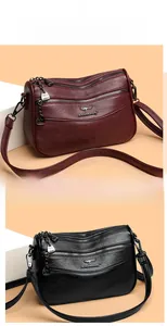 Detail of multi-layer luxury leather shoulder bags in burgundy and black with zipper pockets