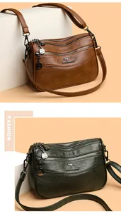 Detailed close-up of multi-layer leather crossbody bag with three zipper compartments