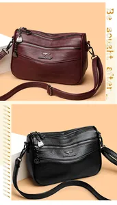Detail of multi-layer litchi leather crossbody bags in burgundy and black with gold accents