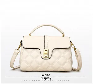 Détail du sac à main blanc crème avec motif matelassé et fermoir pivotant doré chic