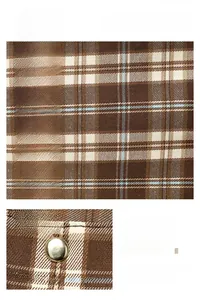 Macro detail of brown plaid fabric texture and premium golden metal magnetic clasp