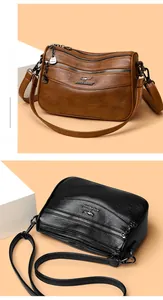Detail view of multi-layer leather crossbody bags with zipper sections and adjustable straps