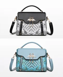 Detail van zwarte en blauwe handtassen met Chinees borduurwerk en een zwanensluiting