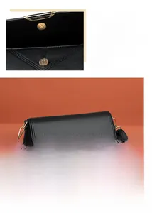 Detail of black lychee leather bag featuring gold hardware and magnetic snap closure