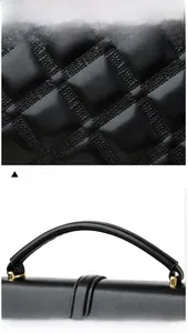 Détail macro du sac en cuir noir montrant la texture gaufrée et les ferrures dorées