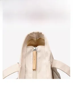 Detailed close-up of smooth silver zipper and brown leather pull on waterproof tote bag